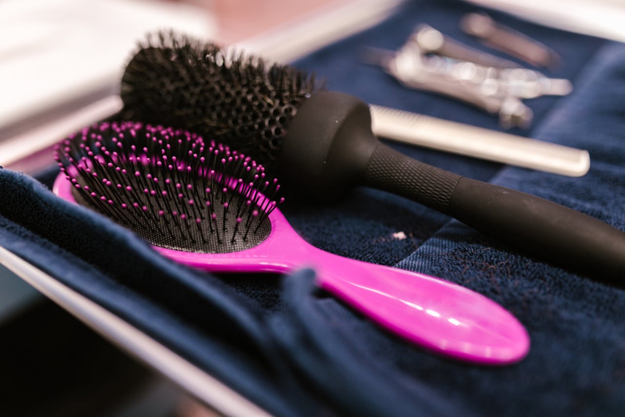 our-services-1 Close-up of pink and black hairbrushes on a towel in a salon setting.