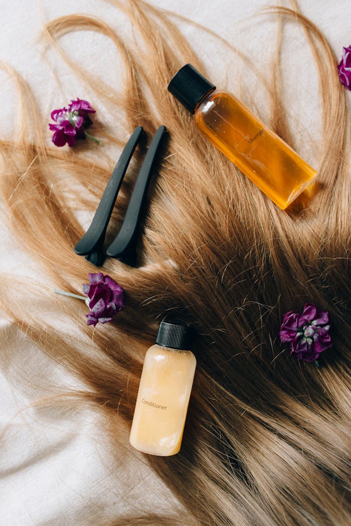 our-services-2 Aesthetic flatlay of hair care items and flowers against a soft background.